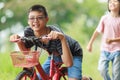 Asian Thai kid boys and girls is brother and sister playing and exercising in the outdoor garden red bicycle boy girl running and Royalty Free Stock Photo