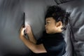 Asian thai kids lying on the bed and watching plays in the smartphone Royalty Free Stock Photo