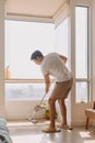 Asian Thai man using mop for cleaning floor in living room apartment, Man do household chores, housework concept. Royalty Free Stock Photo