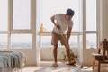 Asian Thai man using mop for cleaning floor in living room apartment, Man do household chores, housework concept. Royalty Free Stock Photo