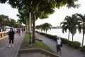 Asian thai people and foreign travelers walking jogging exercise biking bicycle on pathway around pondside in dusk time at Nong