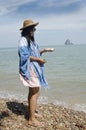 Asian thai woman posing with keep rock and seashell on hand at s