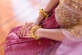 Asian Thai woman sitting with clasp hands legs crossed on the floor in traditional dress