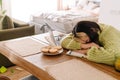 Asian tired girl sleeping while working with laptop at table Royalty Free Stock Photo
