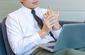 Asian tired overwork male businessman employee in business outfit sitting on sofa working with laptop computer holding hand Royalty Free Stock Photo