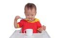 Asian toddler boy child holding toothbrush and brushing teeth in highchair isolated on white with clipping Royalty Free Stock Photo