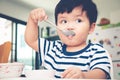 Asian toddler boy eating on high chair