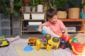 Asian  toddler boy playing with kinetic sand at home, Child playing with toy construction machinery, Montessori education, Royalty Free Stock Photo