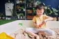 Asian toddler boy playing with sand alone at home, Kid playing with sand toys in urban home garden , Montessori education, Royalty Free Stock Photo