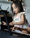 Asian toddler children young kids playing keyboard piano at home Royalty Free Stock Photo