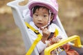 Asian toddler girl in a child bike seat looking to camera Royalty Free Stock Photo