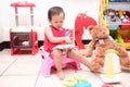 Asian toddler girl child sitting on potty and reading a book with toys & teddy bear, Potty training, Learning to use the Toilet Royalty Free Stock Photo
