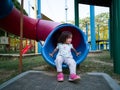 Asian toddler at the playground slide in the morning
