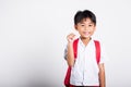 Asian toddler smiling happy wear student thai uniform red pants holding pencil for writers notebook Royalty Free Stock Photo