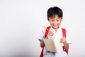 Asian toddler smiling happy wear student thai uniform red pants holding pencil for writers notebook Royalty Free Stock Photo