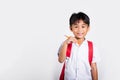 Asian toddler smiling happy wear student thai uniform red pants holding pencil for writers notebook Royalty Free Stock Photo