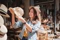 Asian tourist girl shopping, walking in famous local street market looking at beautiful straw hats, happy shopping at Royalty Free Stock Photo