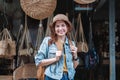 Asian tourist girl shopping, walking in famous local street market looking at beautiful straw hats, happy shopping at Royalty Free Stock Photo