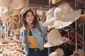 Asian tourist girl shopping, walking in famous local street market looking at beautiful straw hats, happy shopping at Royalty Free Stock Photo