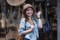 Asian tourist girl shopping, walking in famous local street market looking at beautiful straw hats, happy shopping at Royalty Free Stock Photo