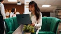 Asian tourist solving a task on laptop before starting vacation