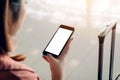 Asian tourist woman hands holding and using smartphone with blank screen waiting for flight in airport lounge