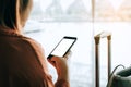 Asian tourist woman hands holding and using smartphone with blank screen waiting for flight in airport lounge