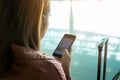 Asian tourist woman hands holding and using smartphone with blank screen waiting for flight in airport lounge