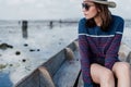 Asian tourist woman wearing a hat and eyeglasses sailing a wooden boat looking at the lake