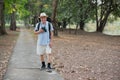 Asian tourists carry backpacks Exploring a forest park in a national park in Thailand Use binoculars to spot birds in the trees Royalty Free Stock Photo