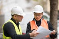 Asian trainee engineer at work on construction site with the senior manager