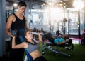 Asian trainer and lady take personal training in fitness club