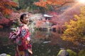 Asian traveler girl in Kimono traditional dress walking in old temple in Autumn season Royalty Free Stock Photo