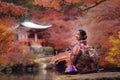 Asian traveler girl in Kimono traditional dress walking in old temple in Autumn season Royalty Free Stock Photo