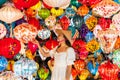 Asian woman is enjoy looking lanterns in old town Hoi An, Woman choosing a lamp at Hoi An ancient town, Vietnam. Closeup Royalty Free Stock Photo