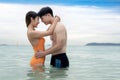 Asian traveller couple playing and sweet togather on the beach between honeymoon day