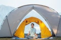 Asian traveller woman post yoga in tent on her camping