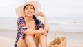 Asian traveller woman sit back and relax on the beach by the sea background on weekend vacation.Concept of happy solo travel