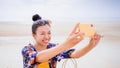 Asian traveller woman sit back and relax on the beach by the sea background on weekend vacation.Concept of happy solo travel