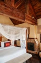 Asian tropical bedroom four poster bed white curtain and fireplace