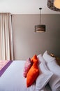 Asian tropical hotel room with bed and colourful pillows