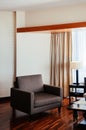 Asian tropical style hotel room wood floor with contemporary fabric armchair