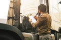 Asian truck driver holding clipboard inspecting safety maintenance checklist of modern semi truck. Royalty Free Stock Photo