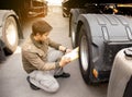 Asian a truck driver holding clipboard inspecting safety maintenance checklist a truck wheels. Royalty Free Stock Photo