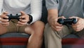 Asian two age generations men family old father embracing young adult son having fun enjoying play video game Royalty Free Stock Photo