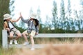 Asian two children raise give me five and sitting on the white fence outdoors, adventure and tourism for destination and leisure t