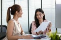 Asian two woman business office discussing financial accounting papers working company profits, Female manager brainstorming Royalty Free Stock Photo