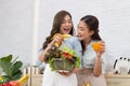 Asian two women wearing  sportswear eat healthy foods in kitchen. Young beautiful girl  happy and enjoy eating fruits healthy Royalty Free Stock Photo