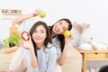 Asian two women wearing sportswear eat healthy foods in kitchen. Young beautiful girl happy and enjoy eating fruits healthy Royalty Free Stock Photo