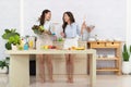 Asian two women wearing sportswear eat healthy foods in kitchen. Young beautiful girl happy and enjoy eating fruits healthy Royalty Free Stock Photo